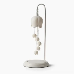 Chyme Charge table lamp side three-quarter angle showing curved metal chains and ceramic bell forms