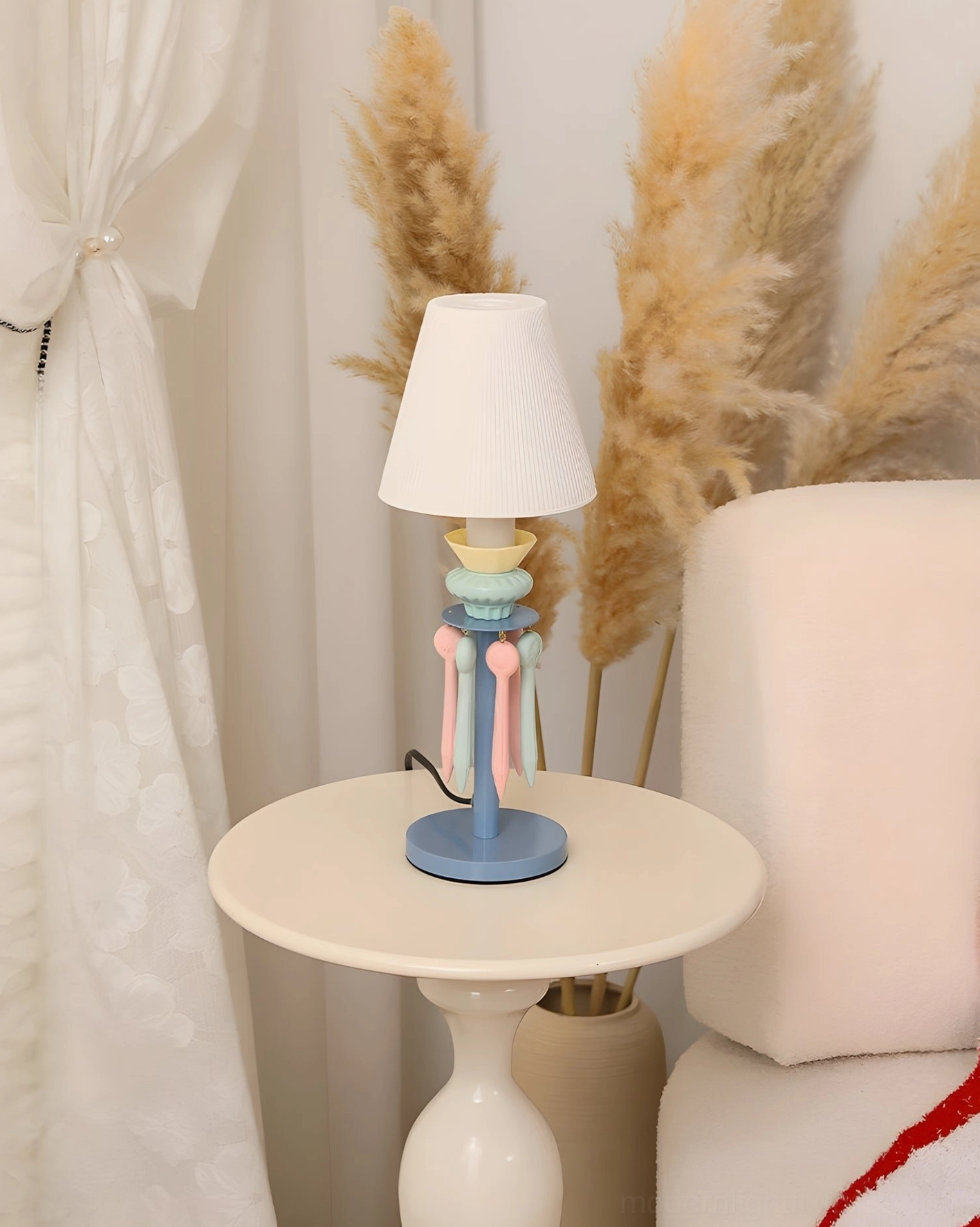 Cielora tassel lamp in pink pastel color on side table in minimalist Scandinavian style interior design setting