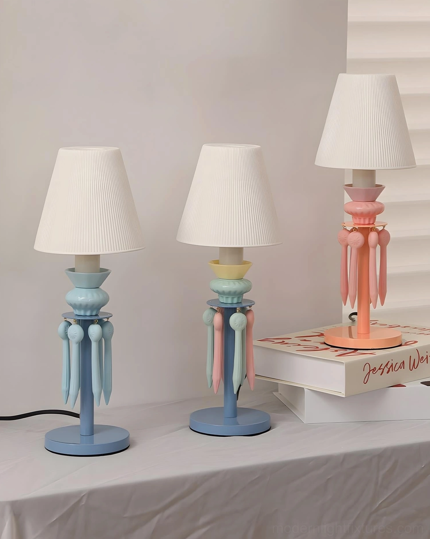 Set of three Cielora tassel table lamps in pink and blue pastel colors displayed on tabletop, high angle product showcase