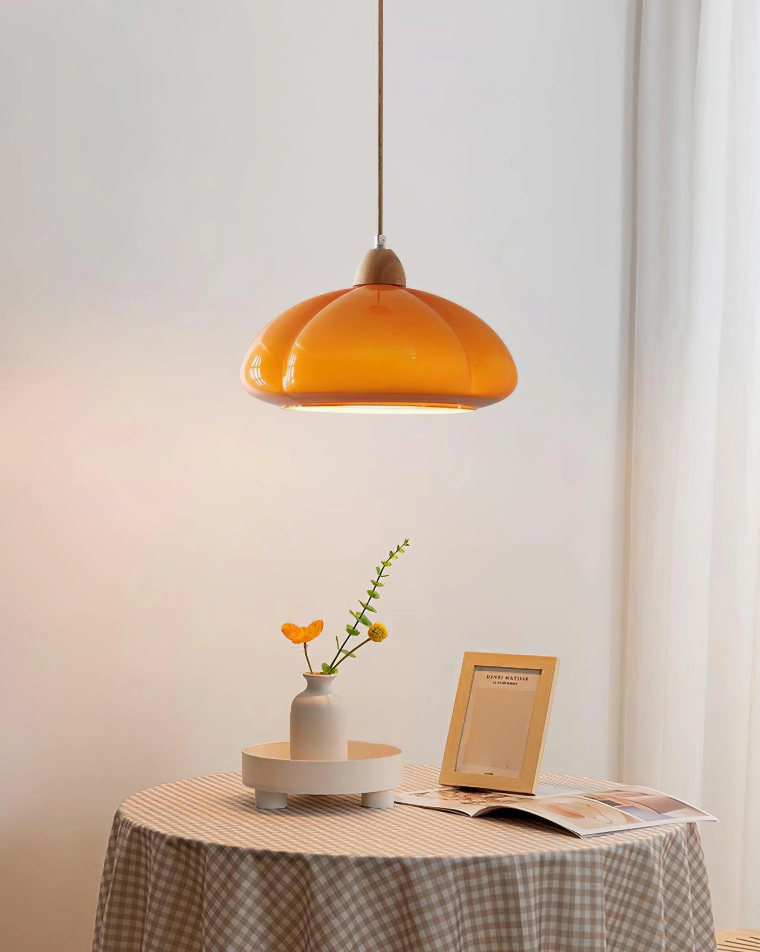 Cipola mushroom pendant lamp with warm orange glass shade in minimalist home dining corner