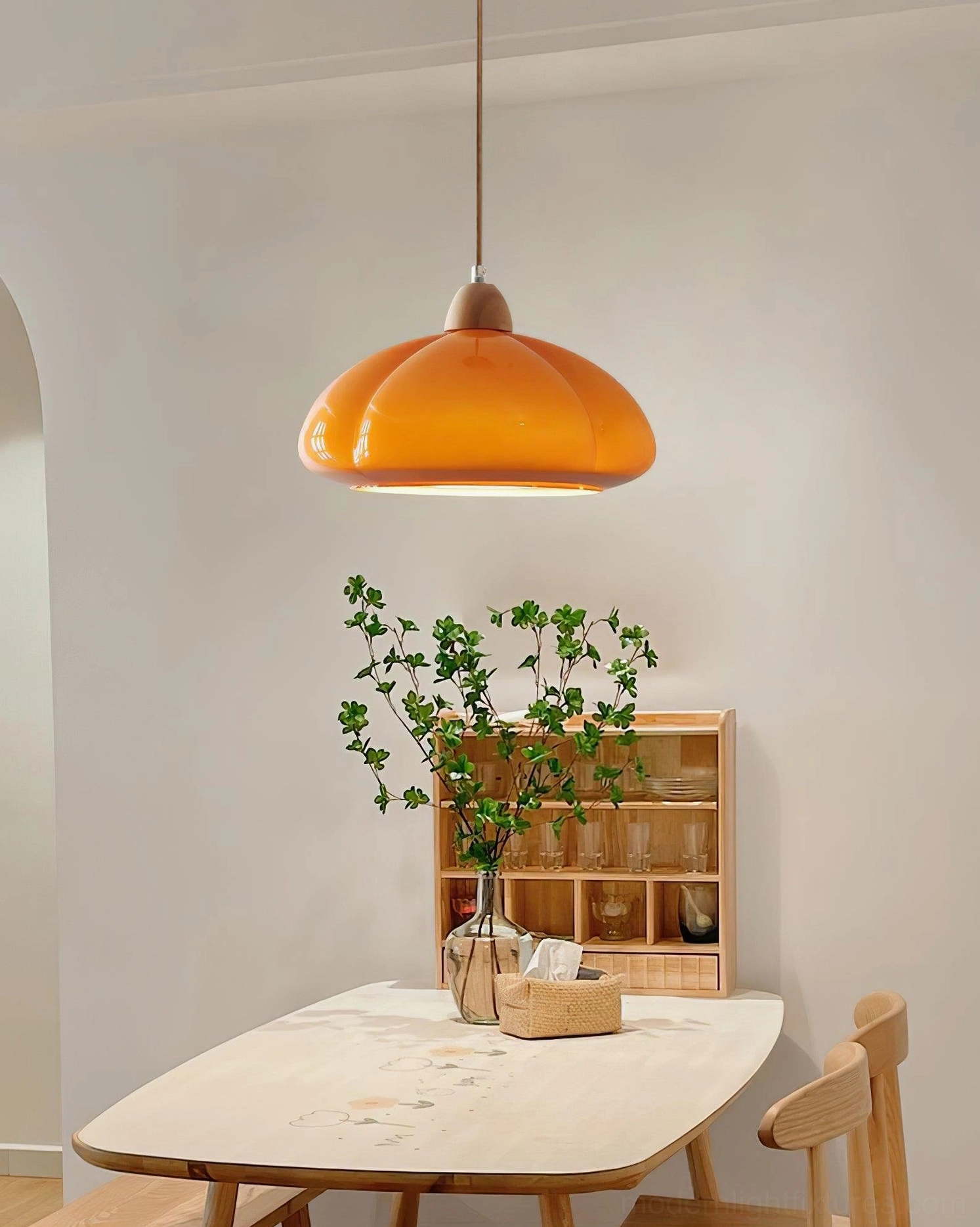 Cipola warm orange pumpkin pendant lamp glowing in Japanese-style dining room with natural wood decor