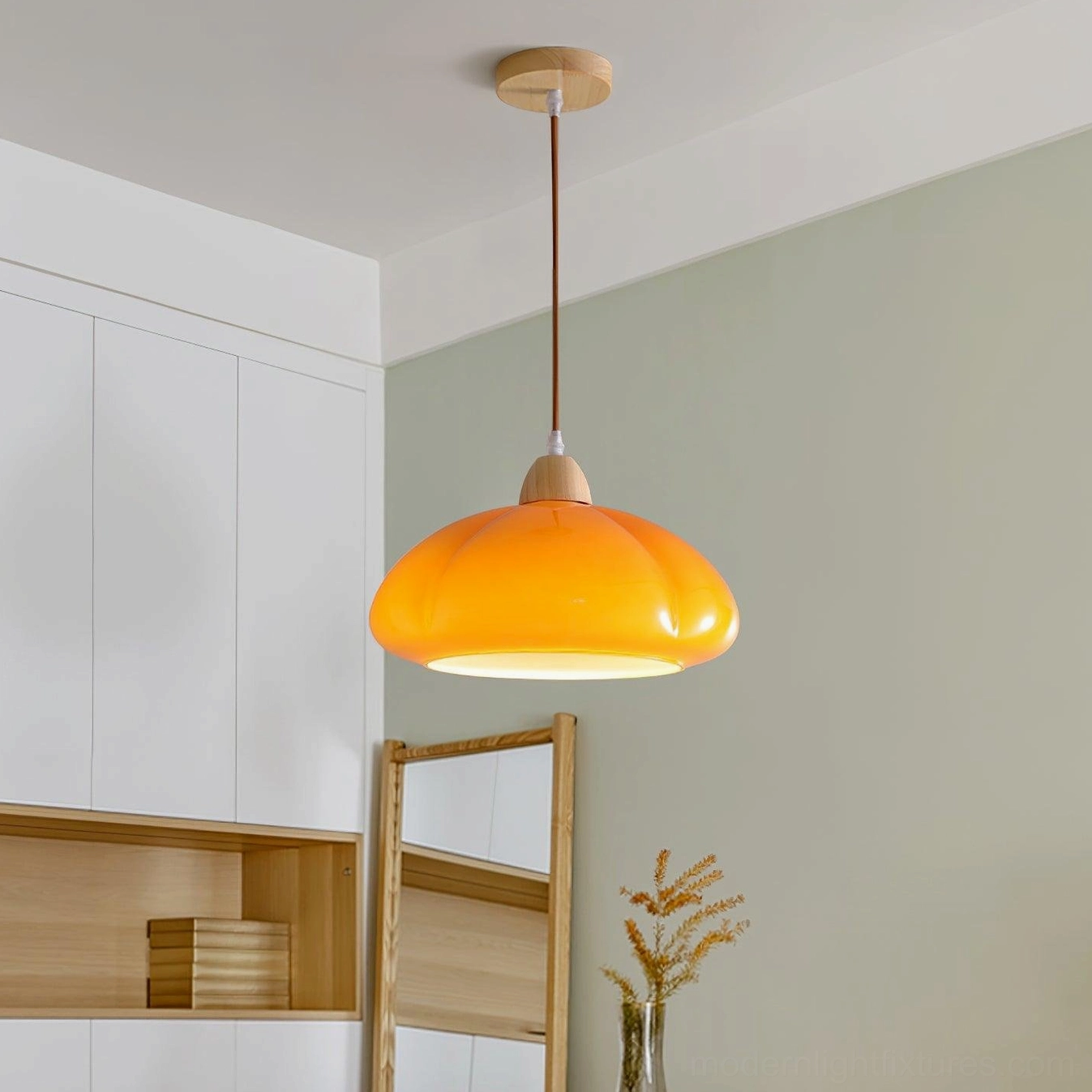 Warm orange Cipola mushroom pendant light glowing in residential dining room, side angle view