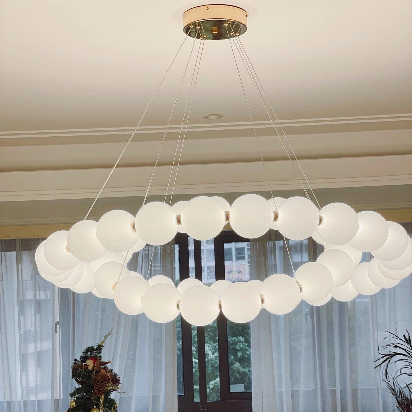 Hanging circular ring pearl pendant light with transparent suspension wires and white frosted acrylic beads