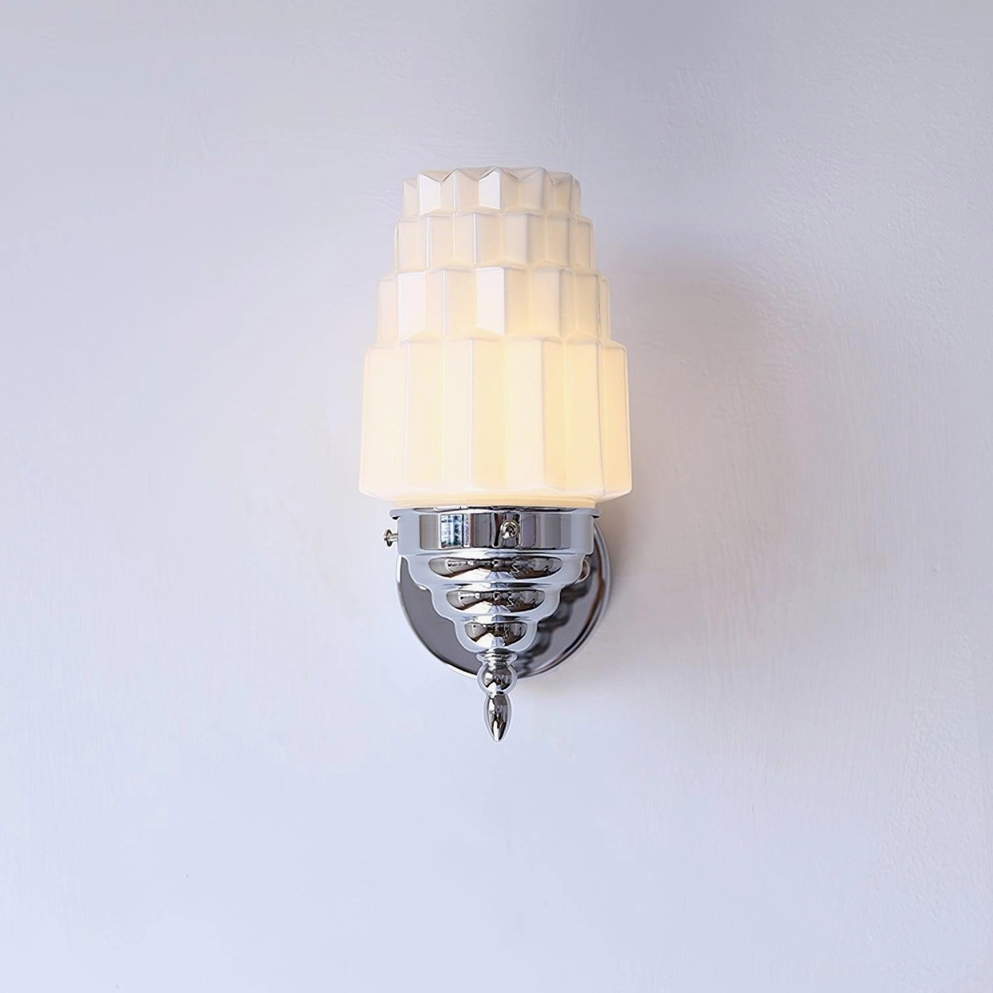 Clairmont art deco wall sconce lit illuminated on white wall showing warm ambient light