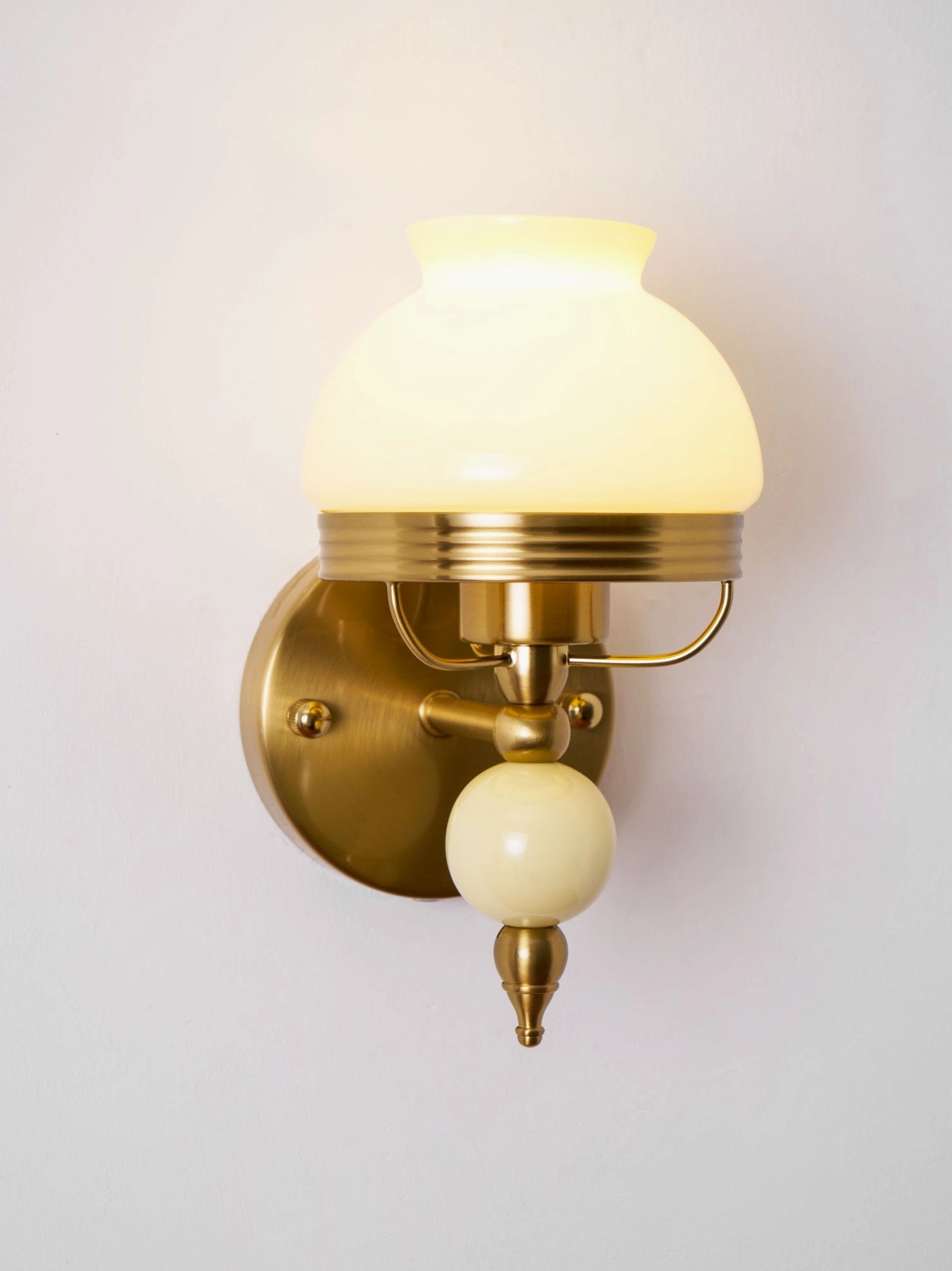Classic vintage wall sconce featuring frosted glass with floral décor and brass metalwork