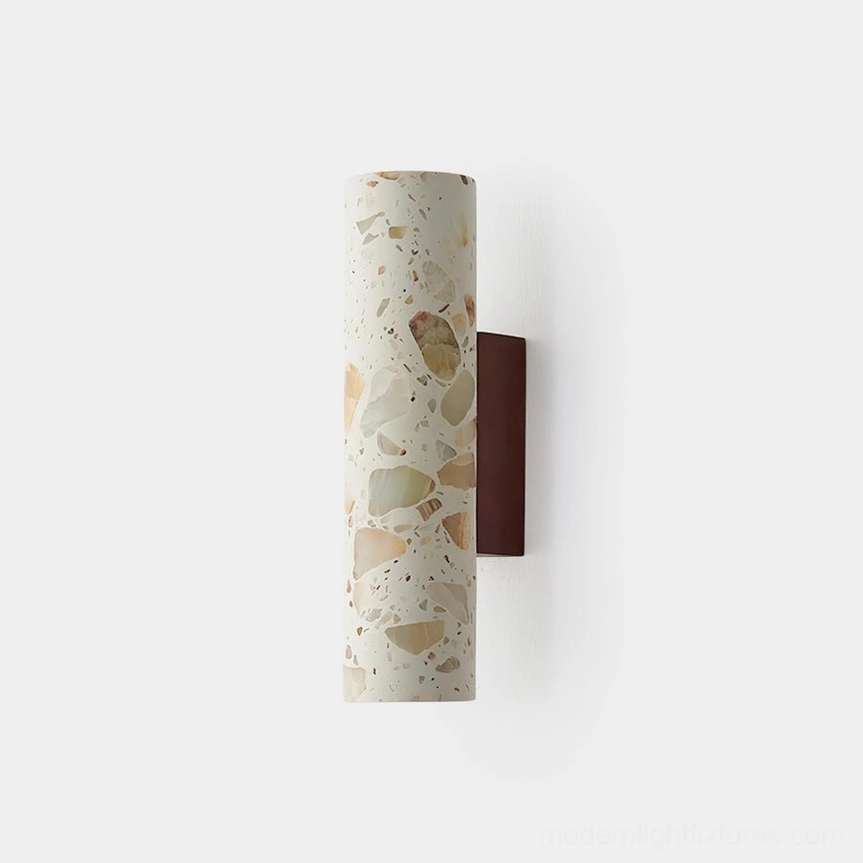 Clasten terrazzo wall sconce front view with cylindrical stone shade and dark wood bracket on white background