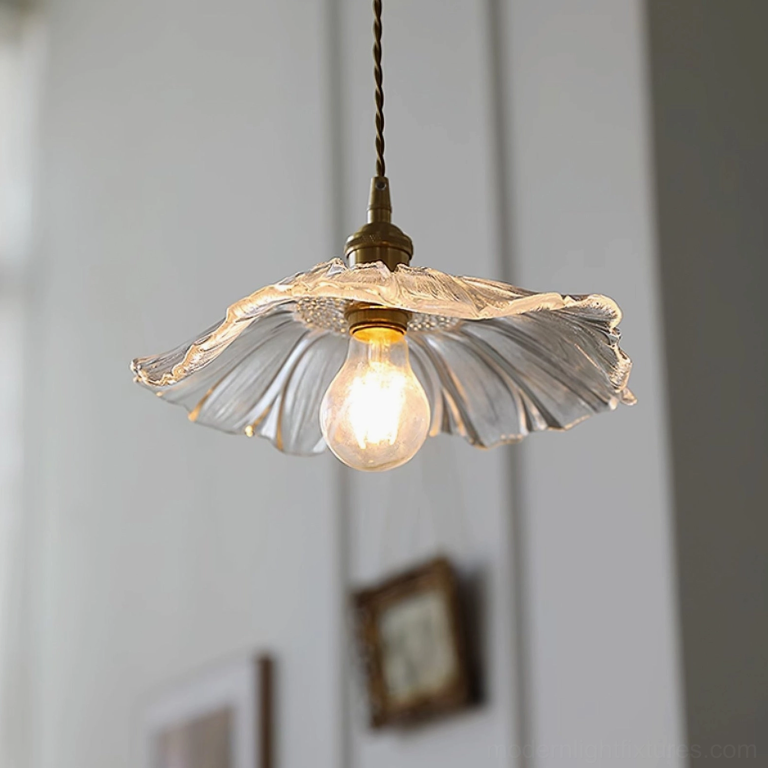 Clear flower glass pendant light with transparent wavy petal shade in indoor hallway setting with warm lighting