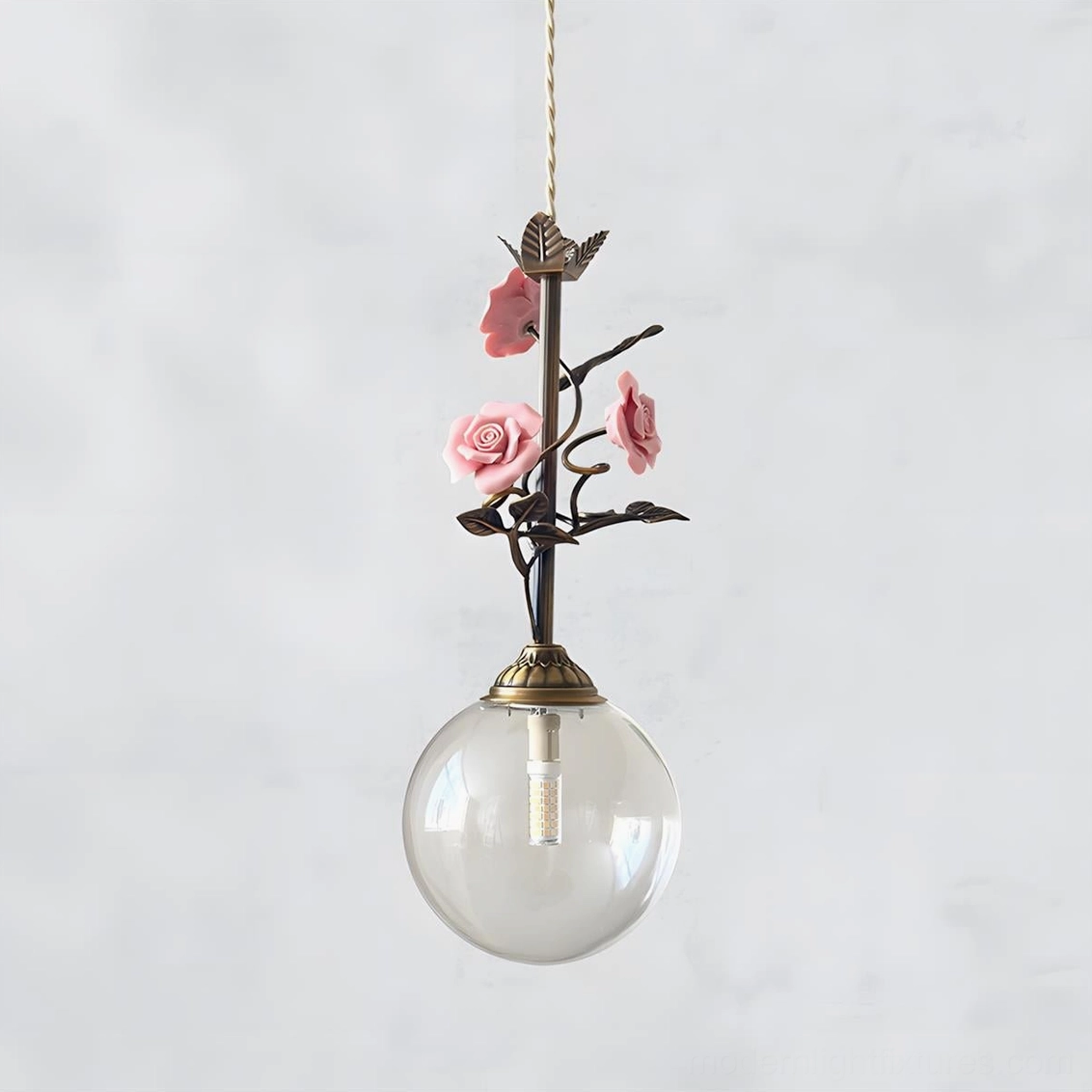 Clear glass floral pendant light with delicate rose ceramic accents, minimalist aesthetic