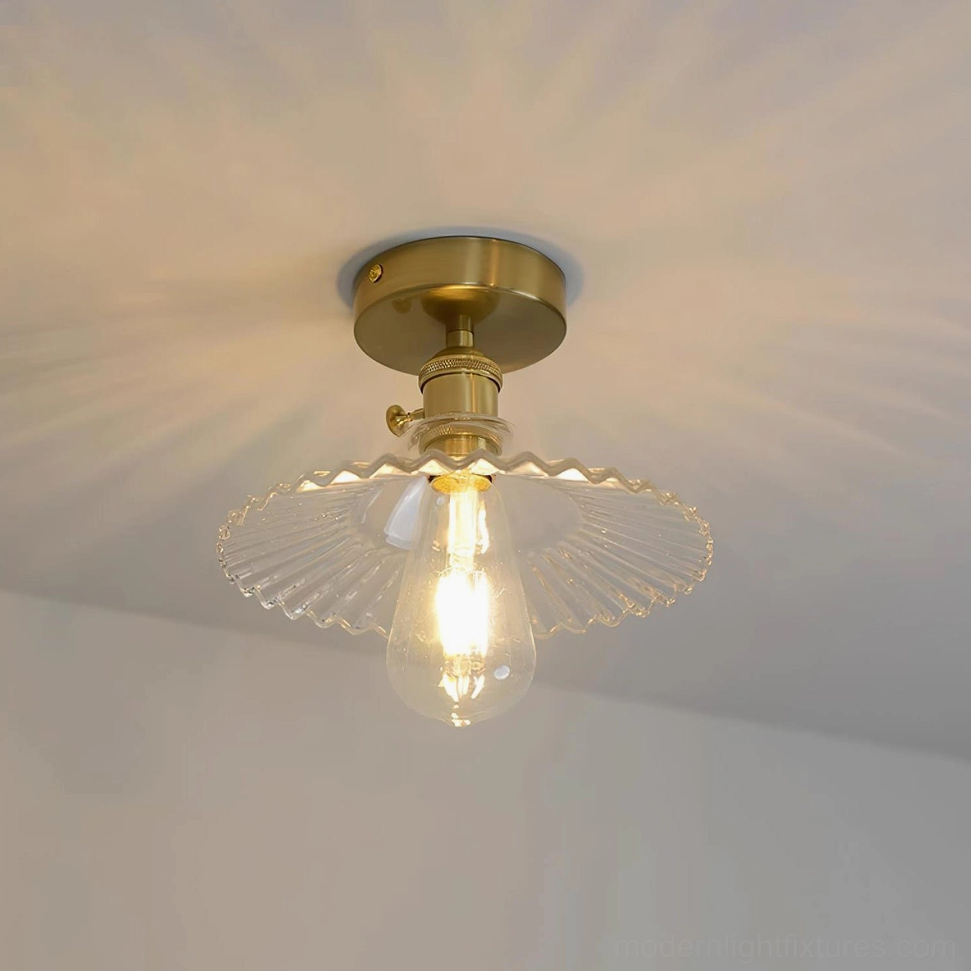 Clear ruffled glass ceiling fixture with brass base and canopy, side profile view