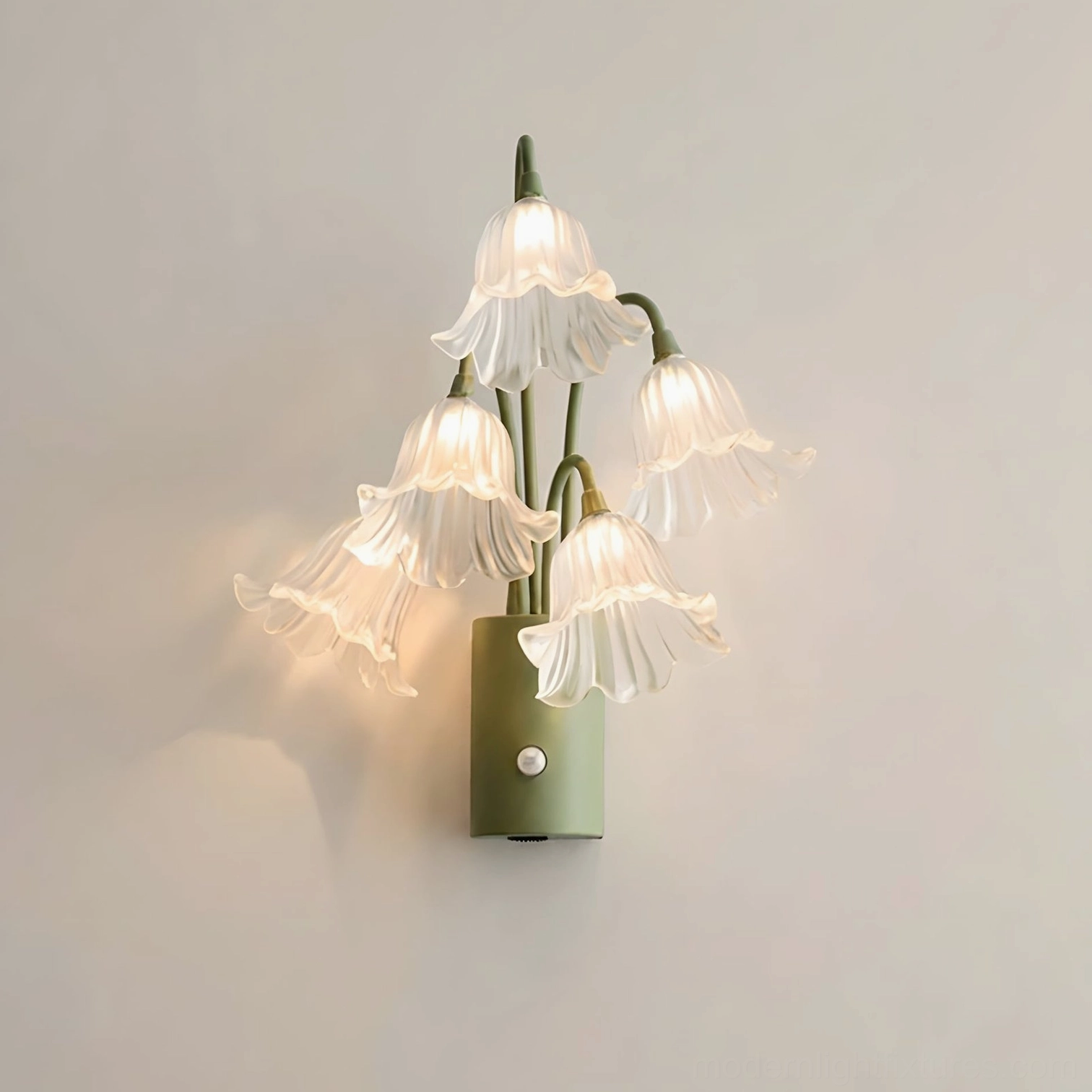 Clear frosted acrylic lily bloom wall sconce with sage green body on white background