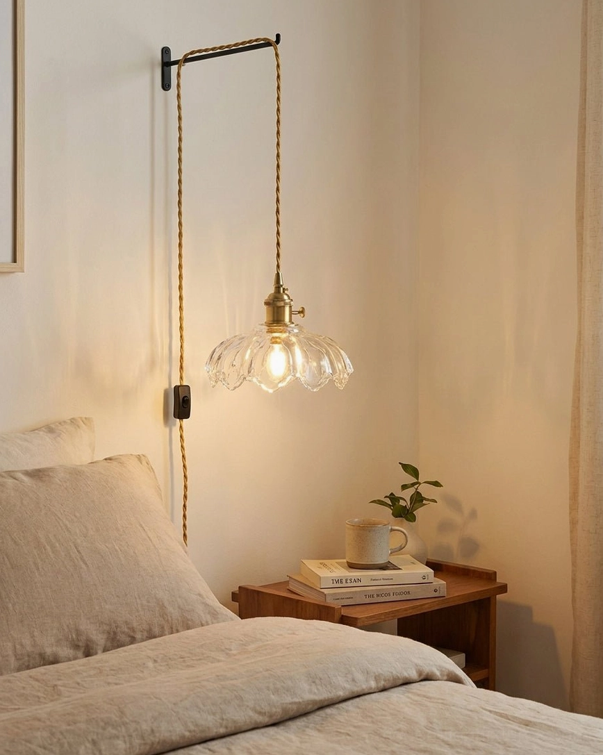 Clear scalloped fluted glass pendant light hanging in bedroom reading corner with warm glowing bulb