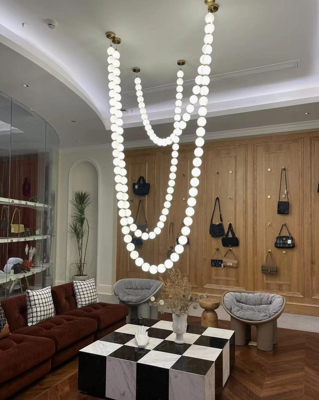 Pearl string chandelier with clear transparent acrylic spheres creating jewel-like lighting effect