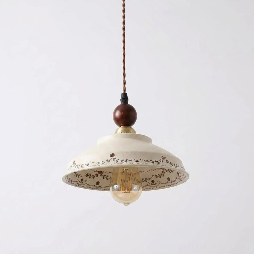 Close-up detail of hand-painted ceramic pendant showing vine and berry pattern, walnut wood bead, polished brass socket cap, exposed Edison bulb warm glow