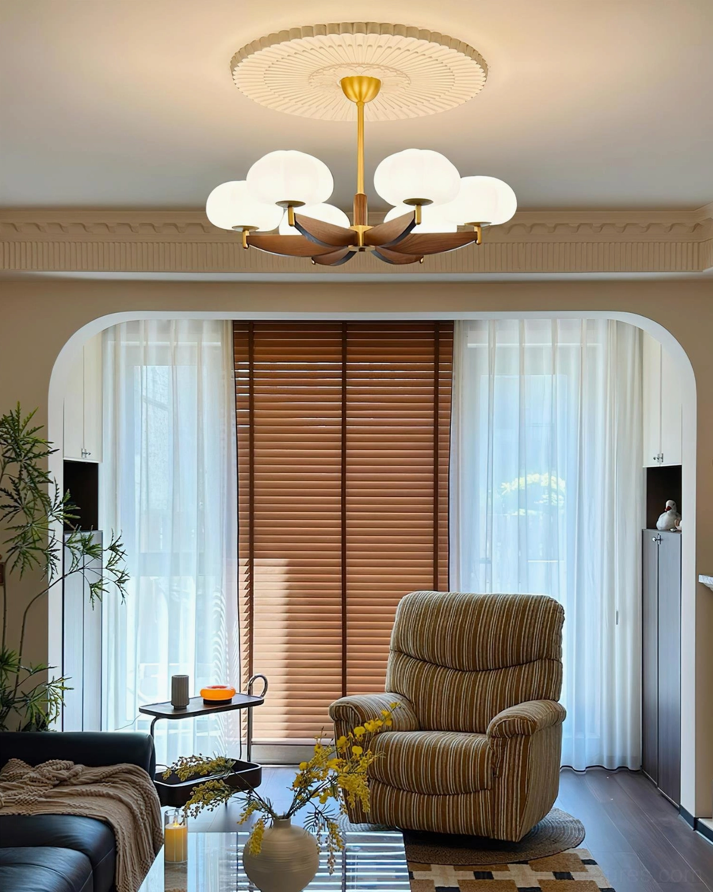 Modern cloud pendant chandelier with 6 glass heads in cozy vintage sitting room with brass frame and dark wood, soft warm ambient lighting from retro armchair