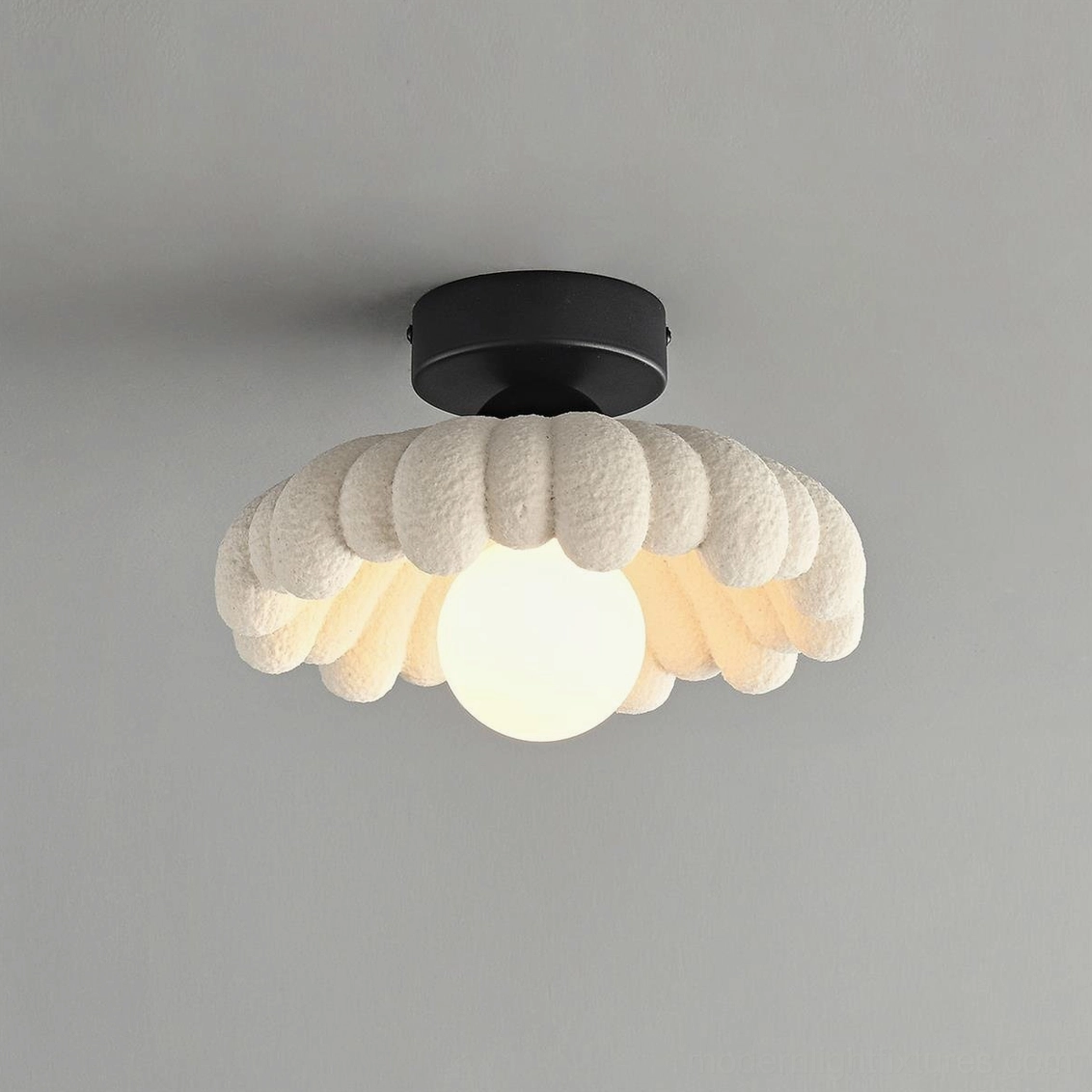 Illuminated Cloud Petal Ceiling Light showing warm central bulb glow and black metal mounting hardware