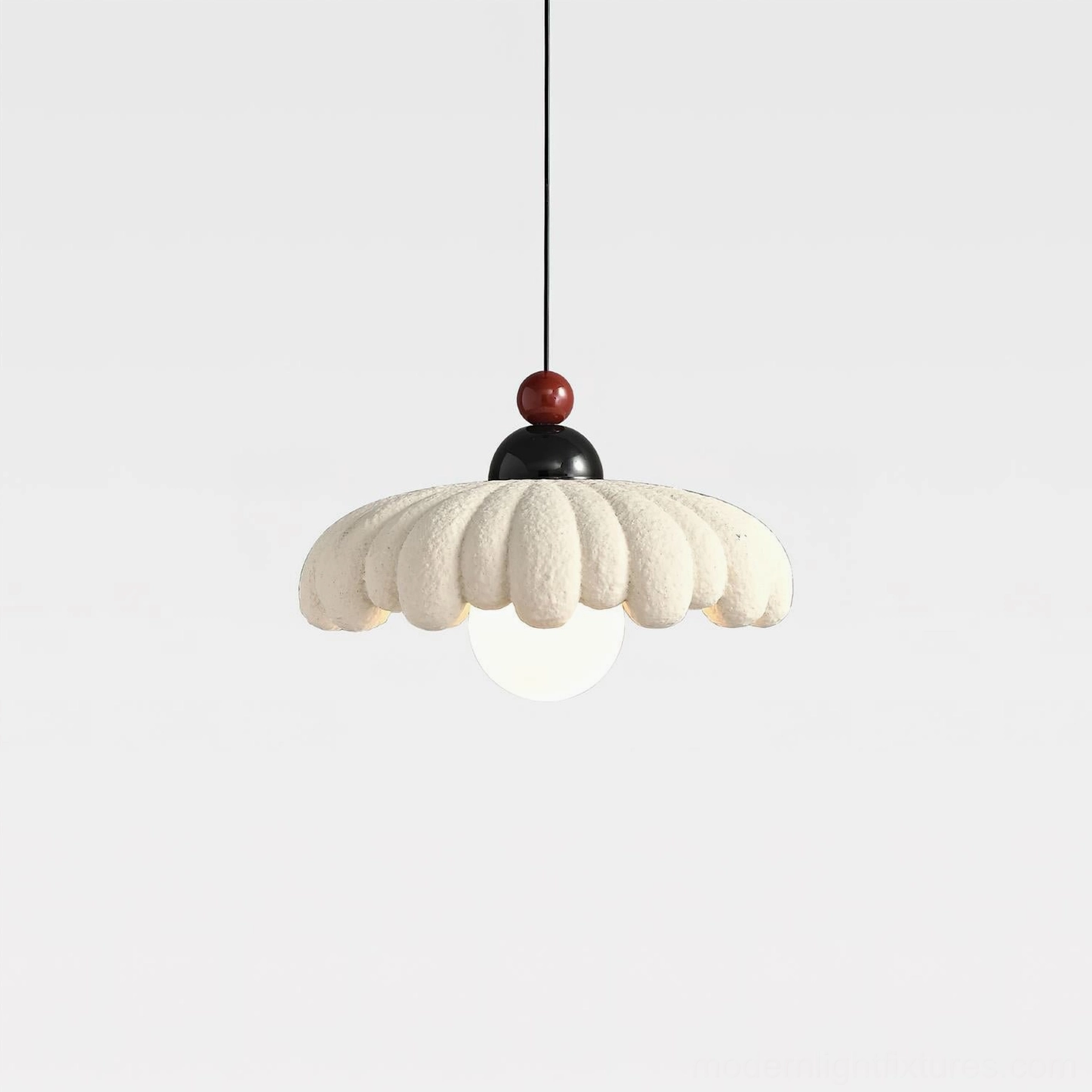Cloudet sculptural pendant lamp with exposed glass bulb beneath cloud-shaped scalloped shade, angled studio view