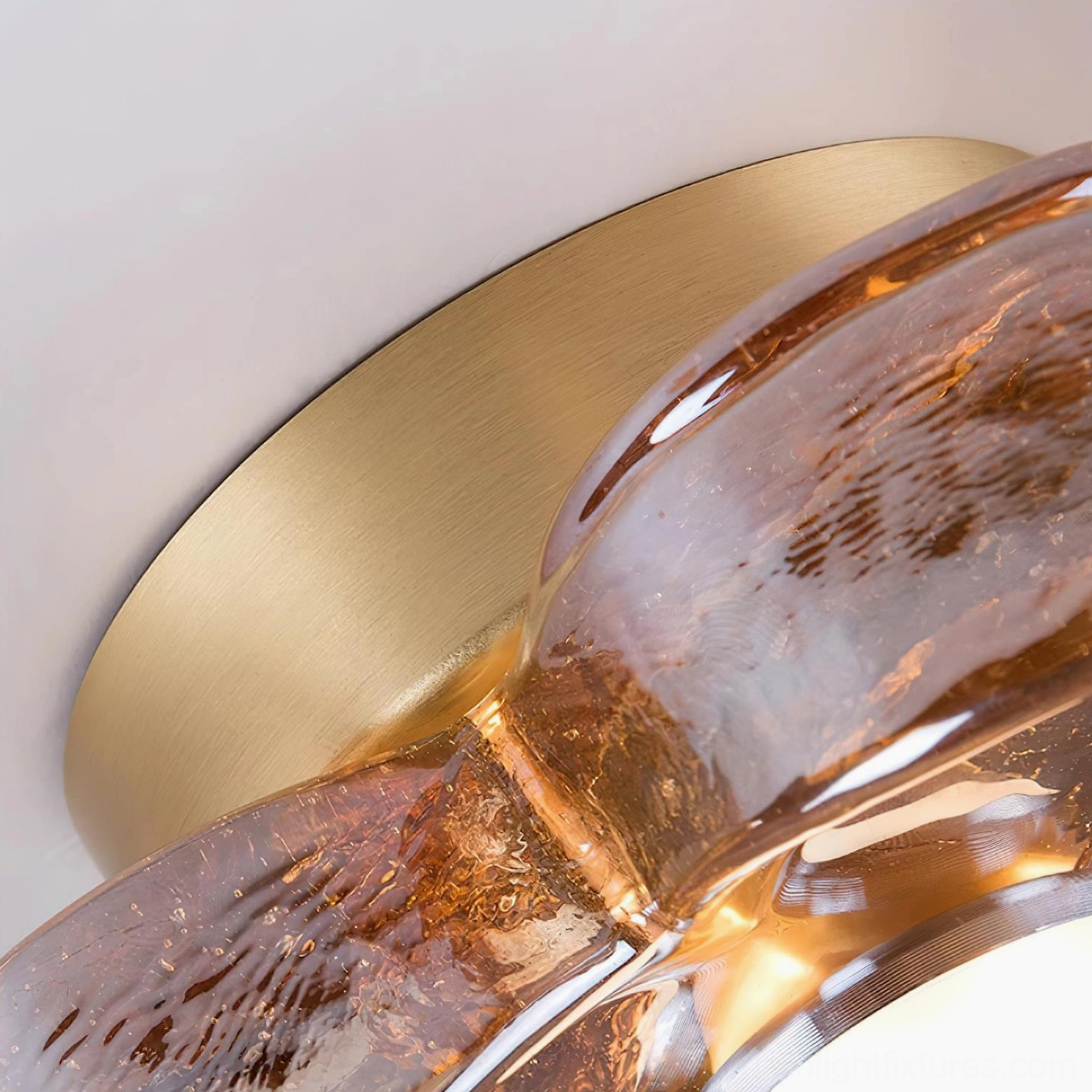 Four-leaf clover ceiling fixture detail showing textured amber glass petals and polished brass mounting base