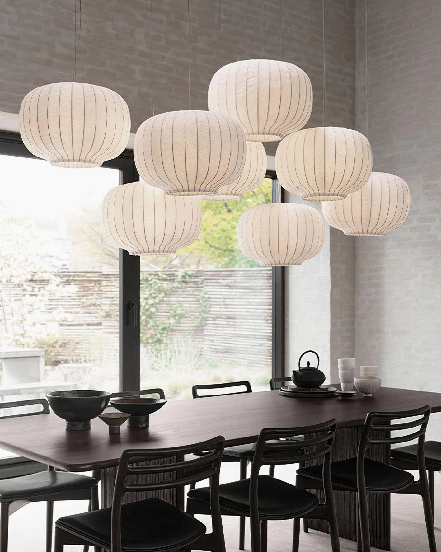 Multiple modern oval ribbed fabric pendant lights creating ambient lighting in contemporary dining room