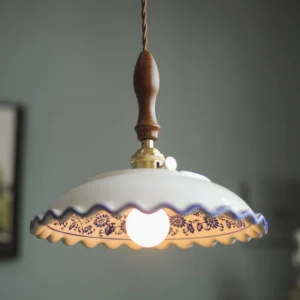 Close-up front view of Cobalisse blue and white pendant light with illuminated bulb, showing hand-painted cobalt patterns and turned walnut suspension handle