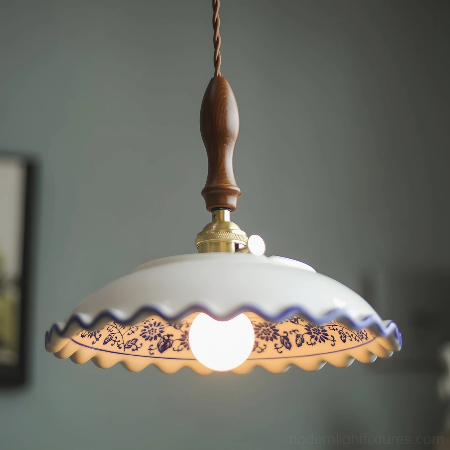 Close-up front view of Cobalisse blue and white pendant light with illuminated bulb, showing hand-painted cobalt patterns and turned walnut suspension handle