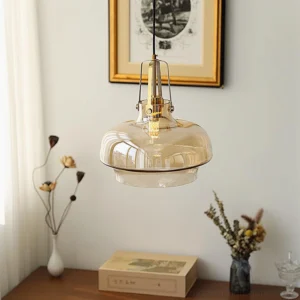 Cognac tinted pendant lamp hanging over vintage desk with brass fixtures, mid-century modern lighting
