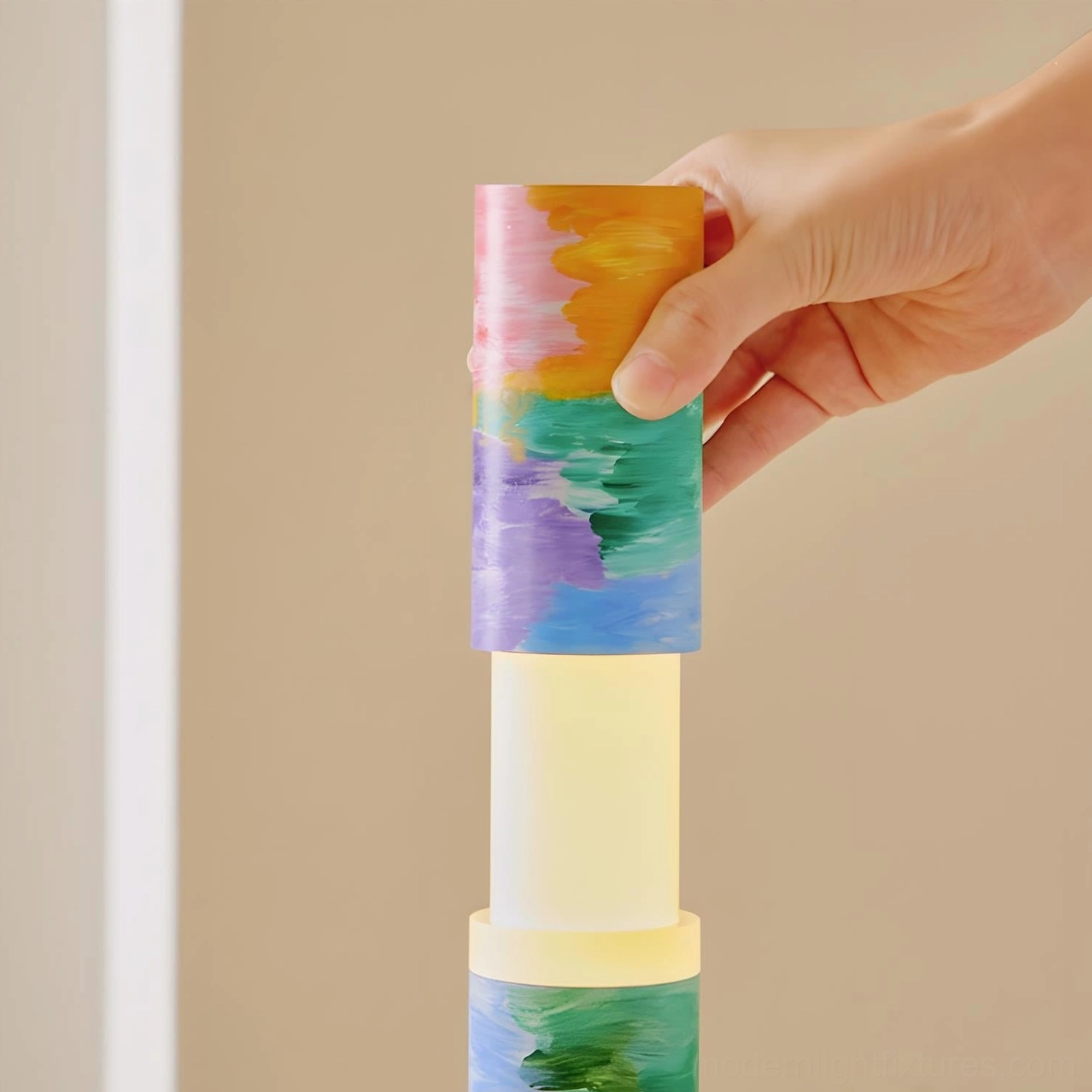 Colorbeam floor lamp assembly detail with hand adjusting painted segment, showing pastel color blocks and matte brushstroke texture