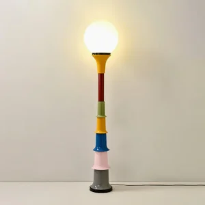 Illuminated colorful floor lamp with glowing globe shade casting warm light - eye-level interior view