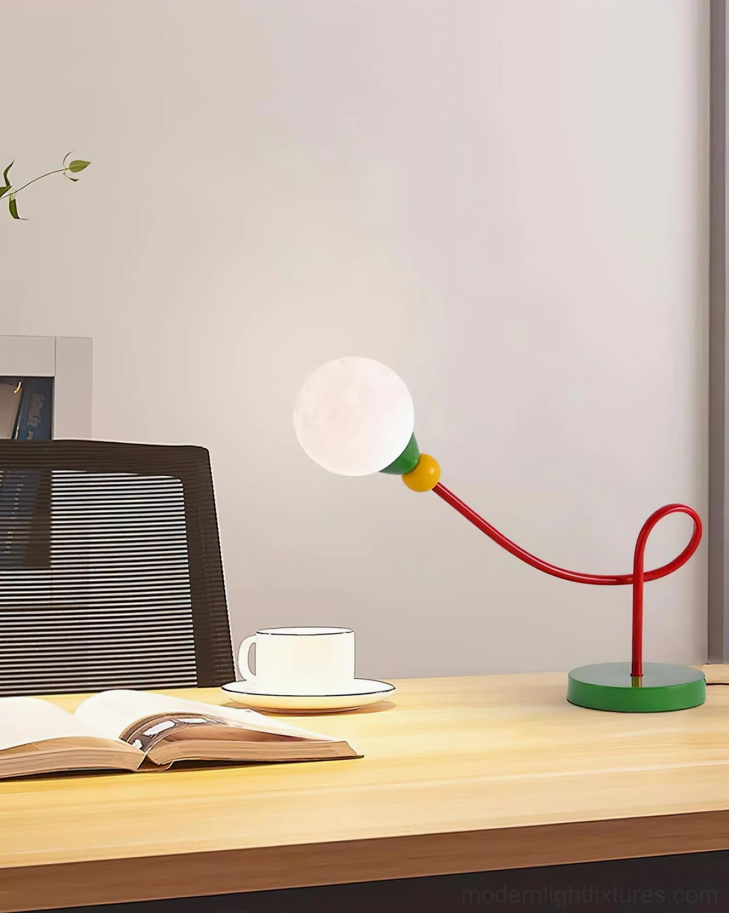 Playful contemporary table lamp positioned on bedroom nightstand next to large leafy potted plant