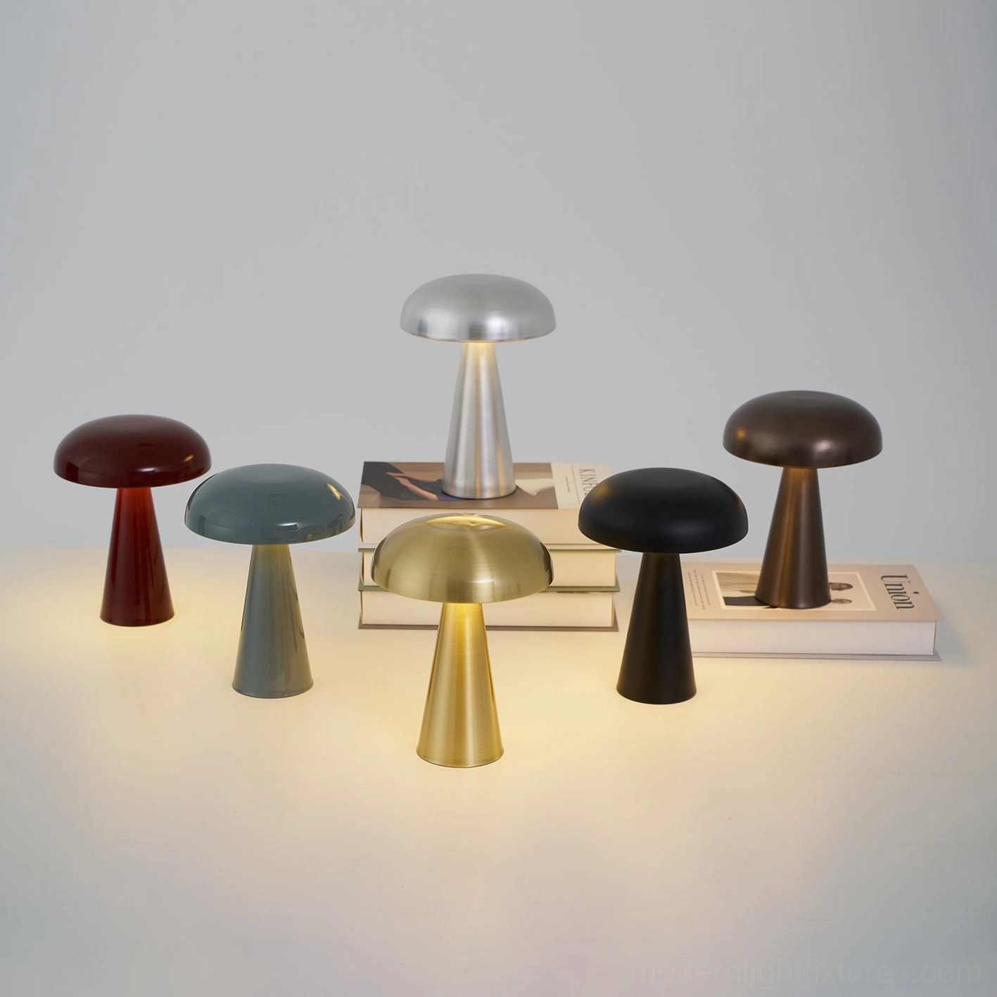 Como cordless table lamp in six aluminum color finishes displayed together - gold, silver, black, gray-blue, red, copper