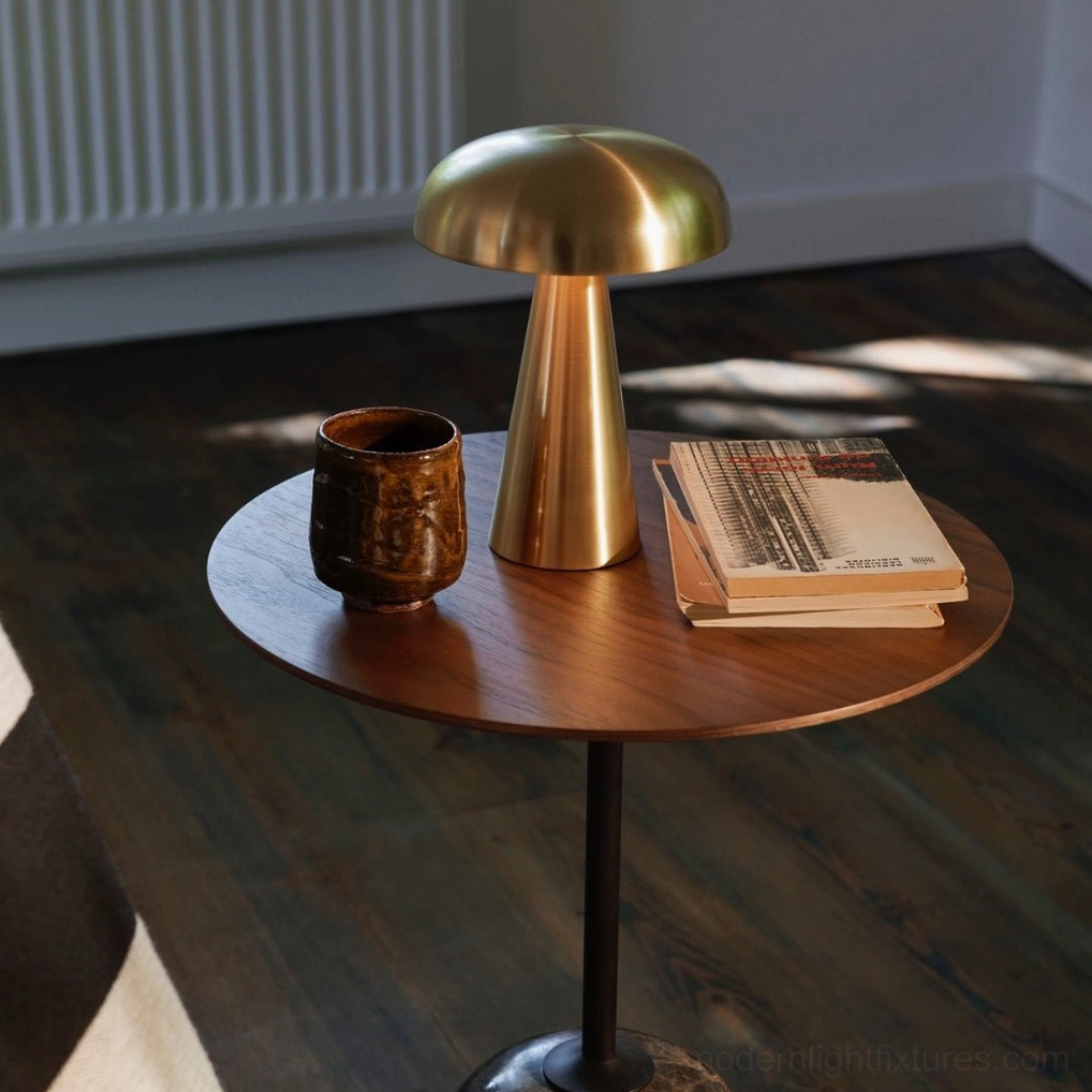 Como modern brass table lamp on side table with coffee cup books and minimalist decor in contemporary living room