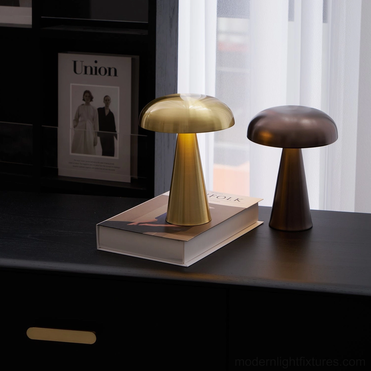 Como table lamp in brass and copper brown finishes on modern console table with stacked books design display