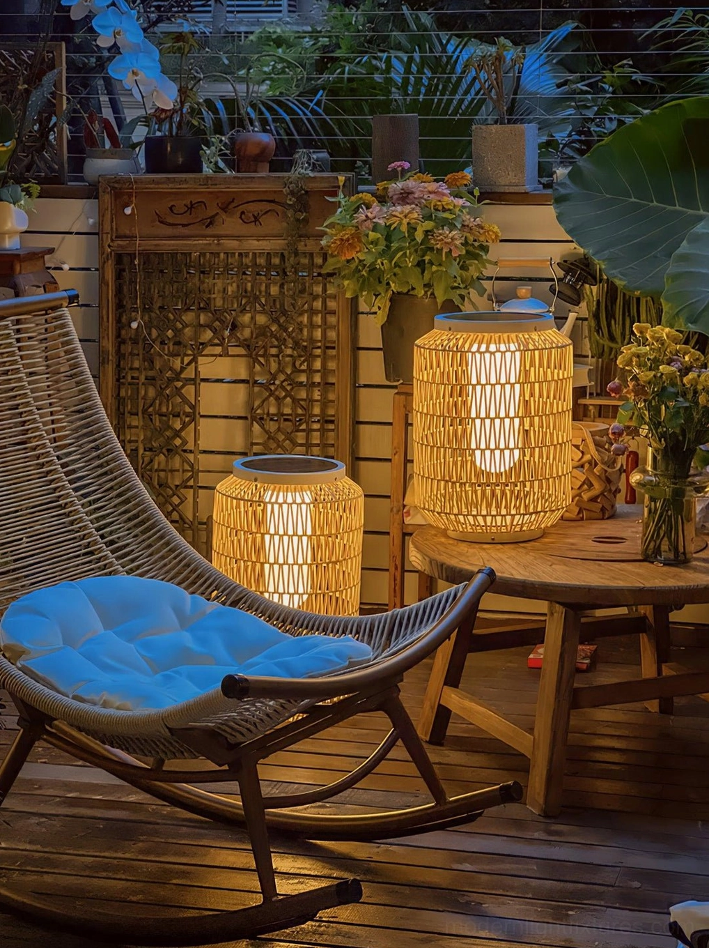 Compact rattan table lamp creating accent lighting in Japanese zen outdoor garden setting