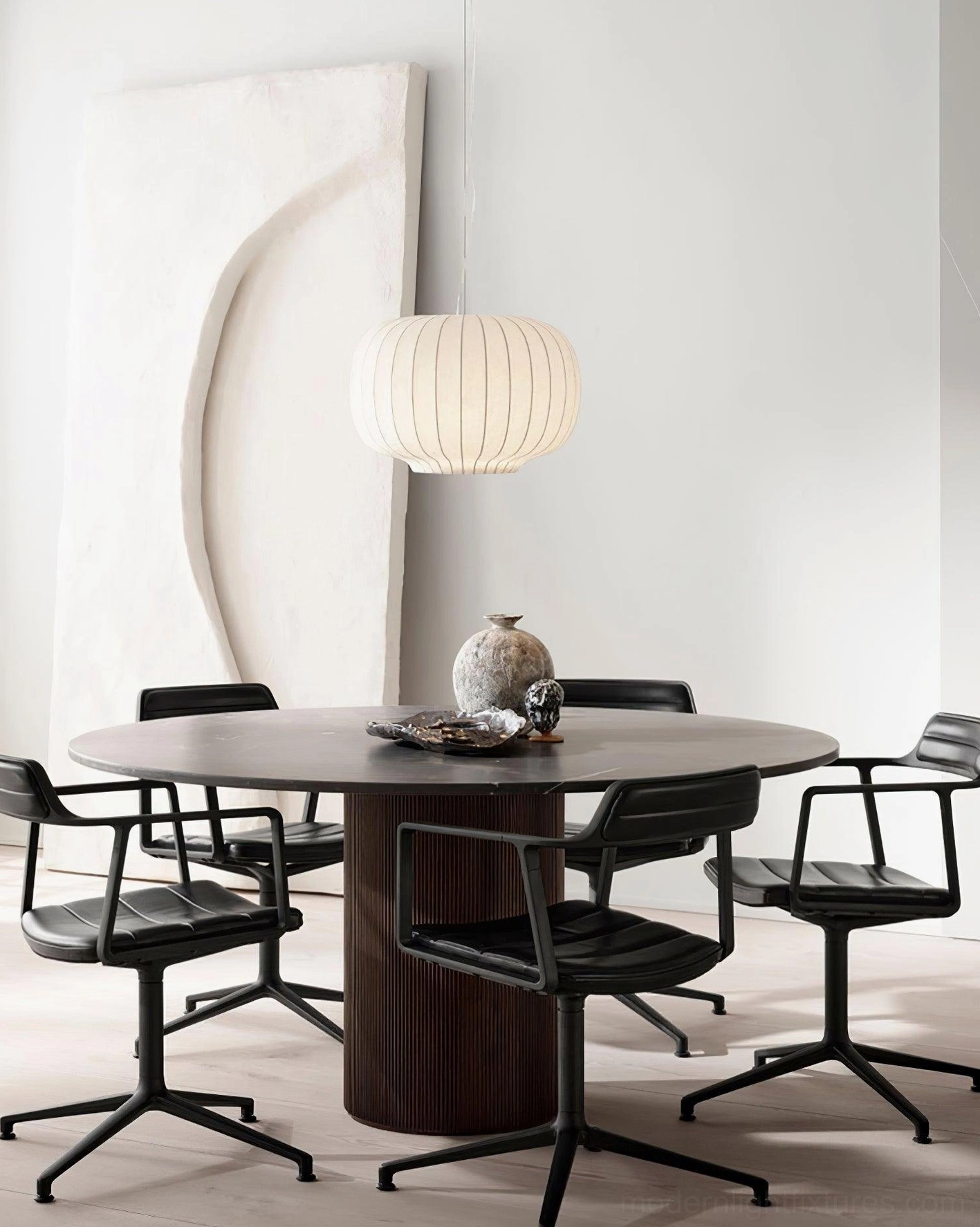 Small oval ribbed pendant light in compact minimalist home dining area with artistic wall decor