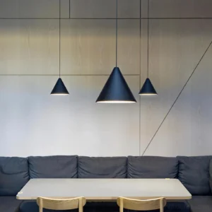 Black industrial pendant lights installed in modern dining room above table, contemporary minimalist hanging fixtures with exposed cables