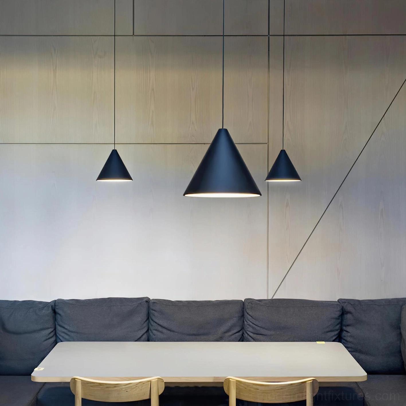Black industrial pendant lights installed in modern dining room above table, contemporary minimalist hanging fixtures with exposed cables