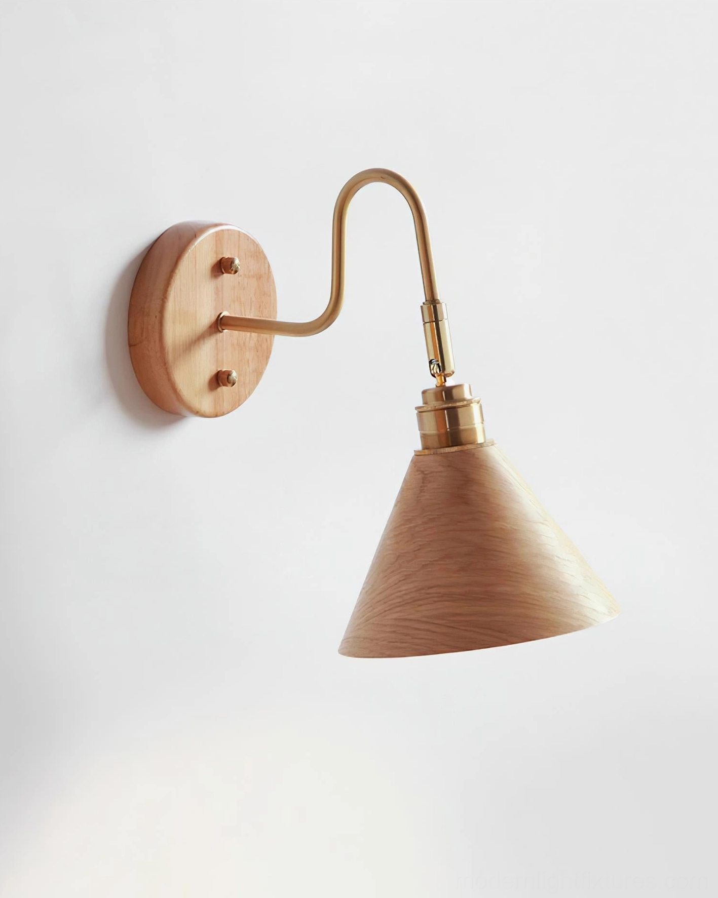 Conira wood and brass wall sconce mounted on white wall - side profile view