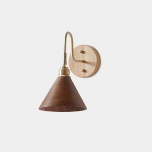 Conira minimalist wall sconce with conical walnut shade and brass curved arm - front view studio photography