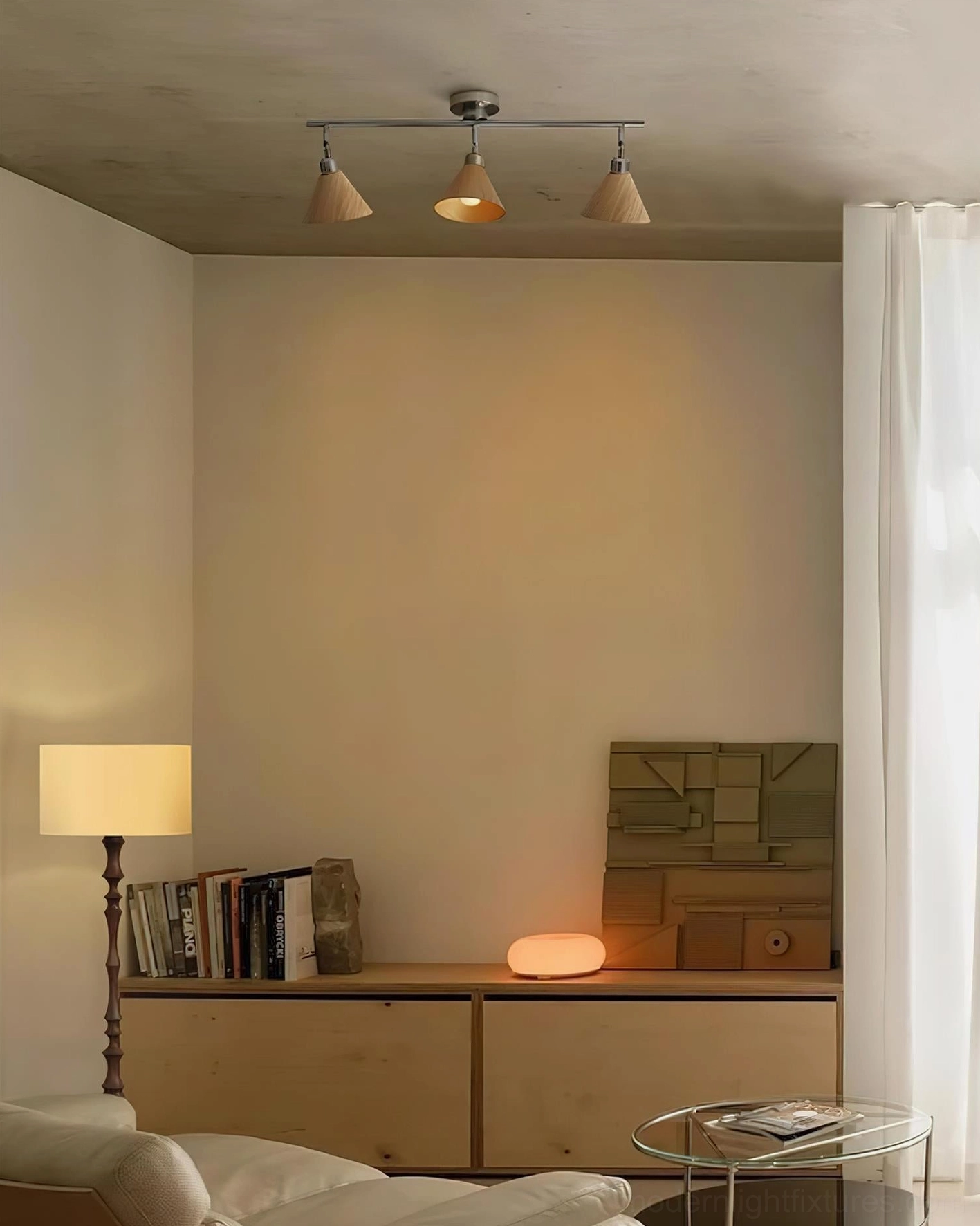 Minimalist Conistra 3-light track ceiling light installed in cozy living room with sofa, neutral wood shades and brushed nickel hardware