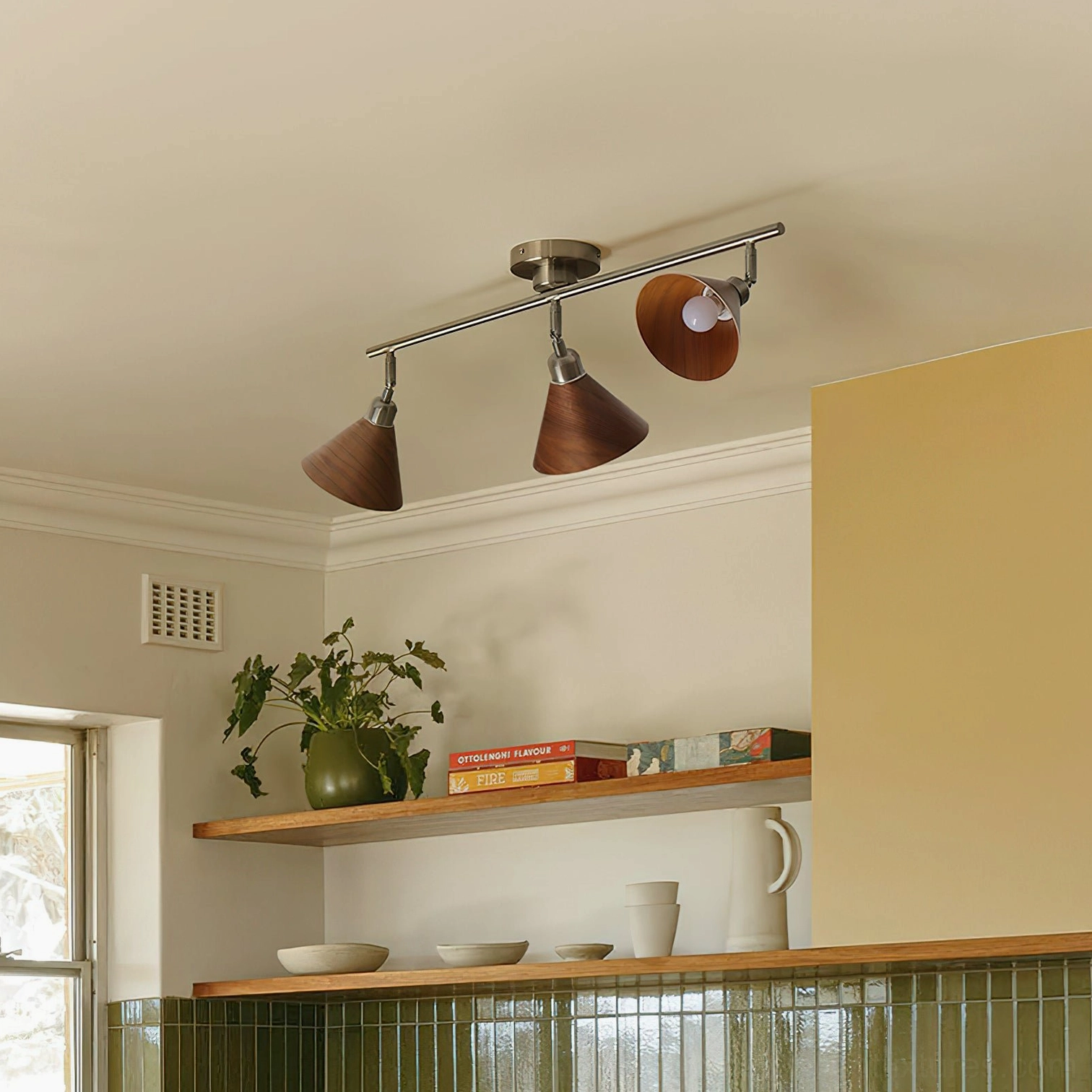 Adjustable 3-light Conistra track ceiling lamp installed in residential living space with wall shelves and cozy home decor
