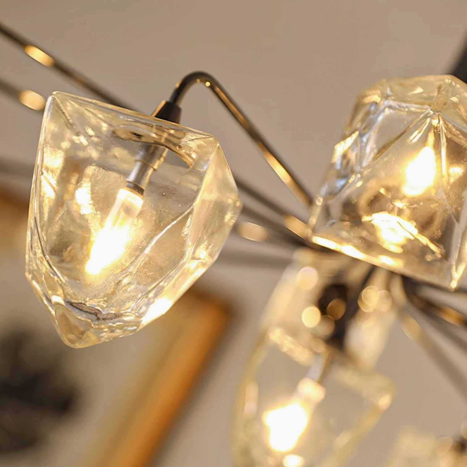 Contemporary brass gold chandelier with clear faceted glass displaying polished metal finish detail