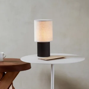 Contemporary table lamp with warm white 3000K LED and integrated USB charging port, three-quarter angle view on Nordic side table