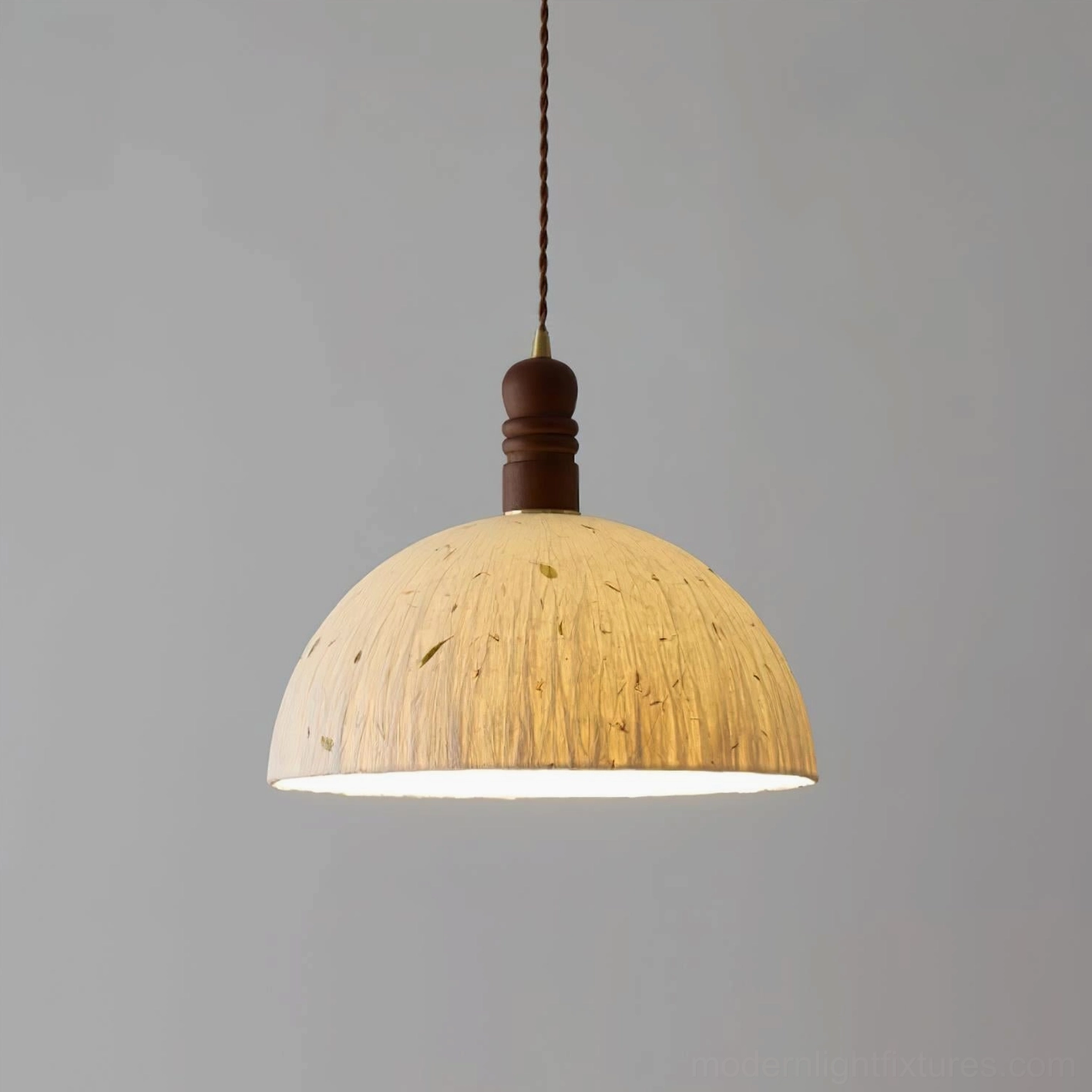 Handcrafted dome pendant lamp suspended in contemporary minimalist room with neutral decor