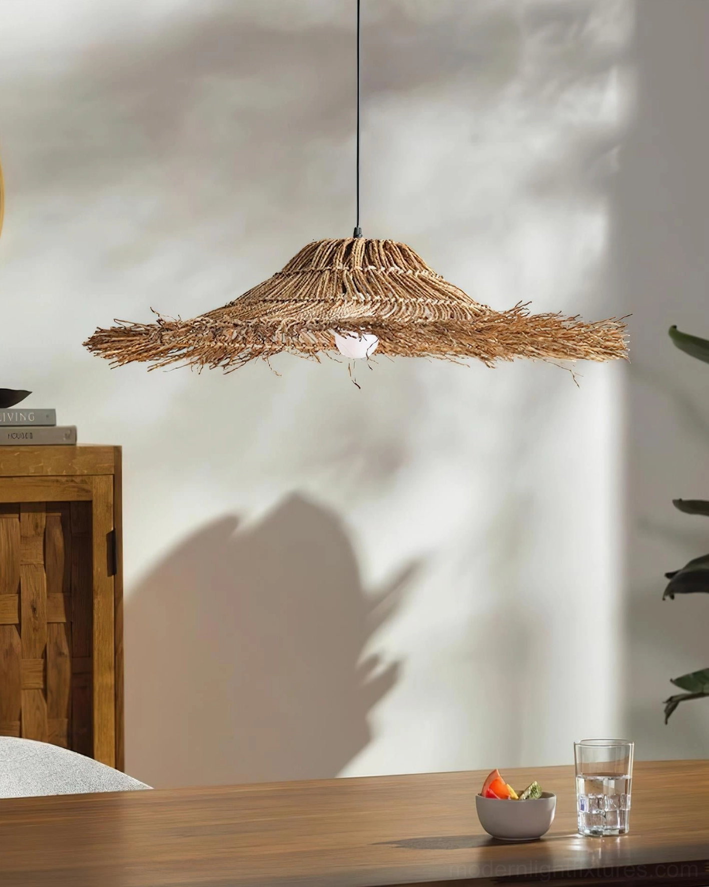 Natural rattan handwoven pendant light suspended in contemporary eclectic living space, warm dappled lighting through shade