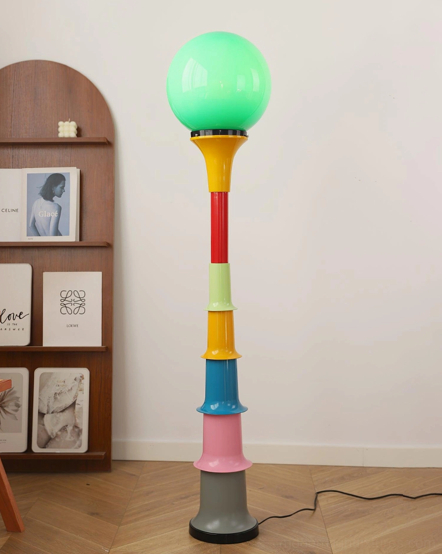 Modern globe floor lamp with color-blocked base in Nordic living room beside sofa with cat and home décor