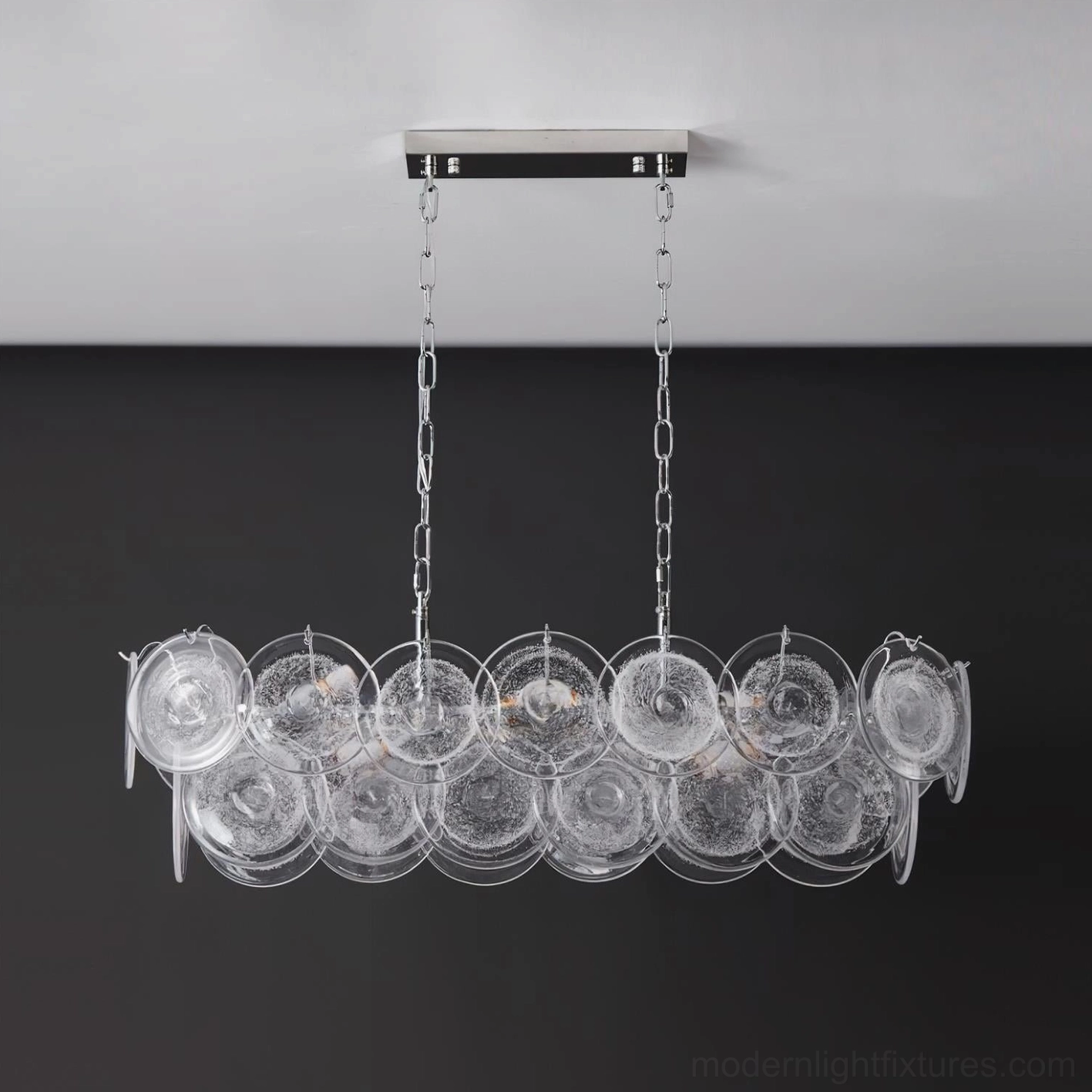 Contemporary linear chandelier with clear and chrome combination creating minimalist modern aesthetic