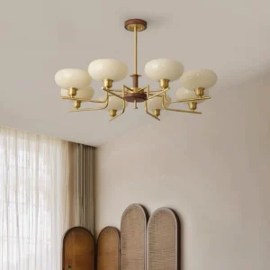 Contemporary multi-head glass chandelier with warm brass metalwork installed in minimalist beige living room interior design