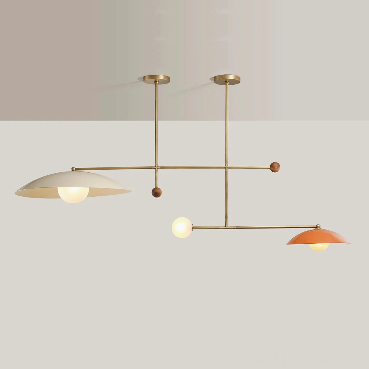 Contemporary pendant light illustrating sculptural composition of brass frame, domed shades, and natural wood elements