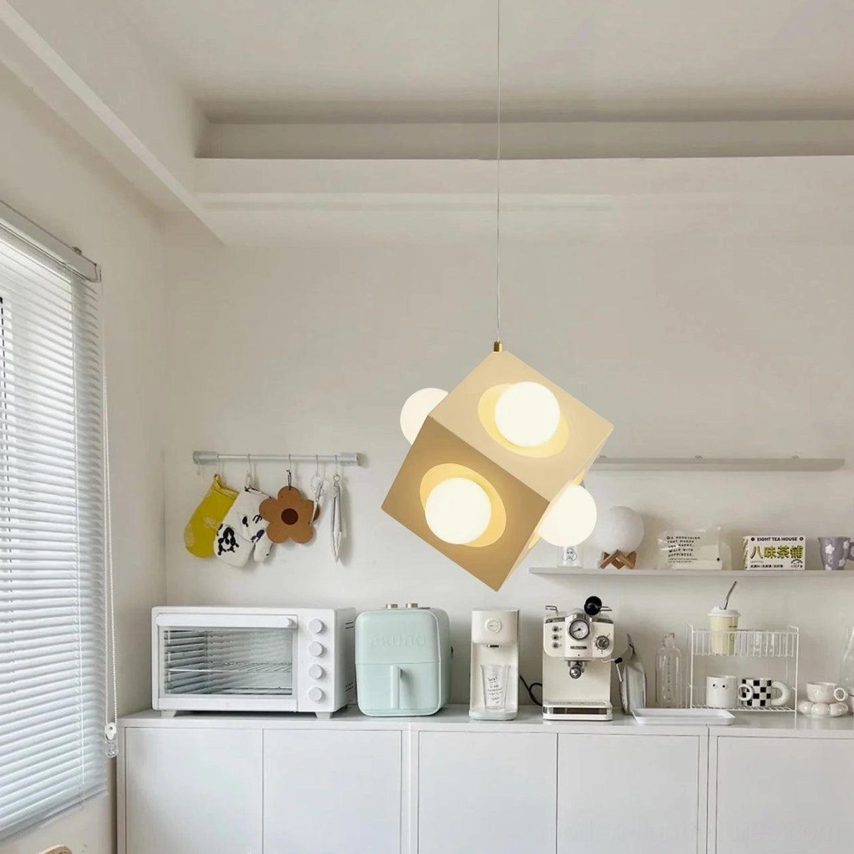 Geometric cubic pendant fixture in residential kitchen with white cabinetry and integrated warm LED