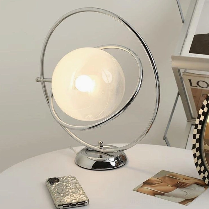 Rotating planet lamp warm ambient lighting on nightstand with mobile phone and magazine