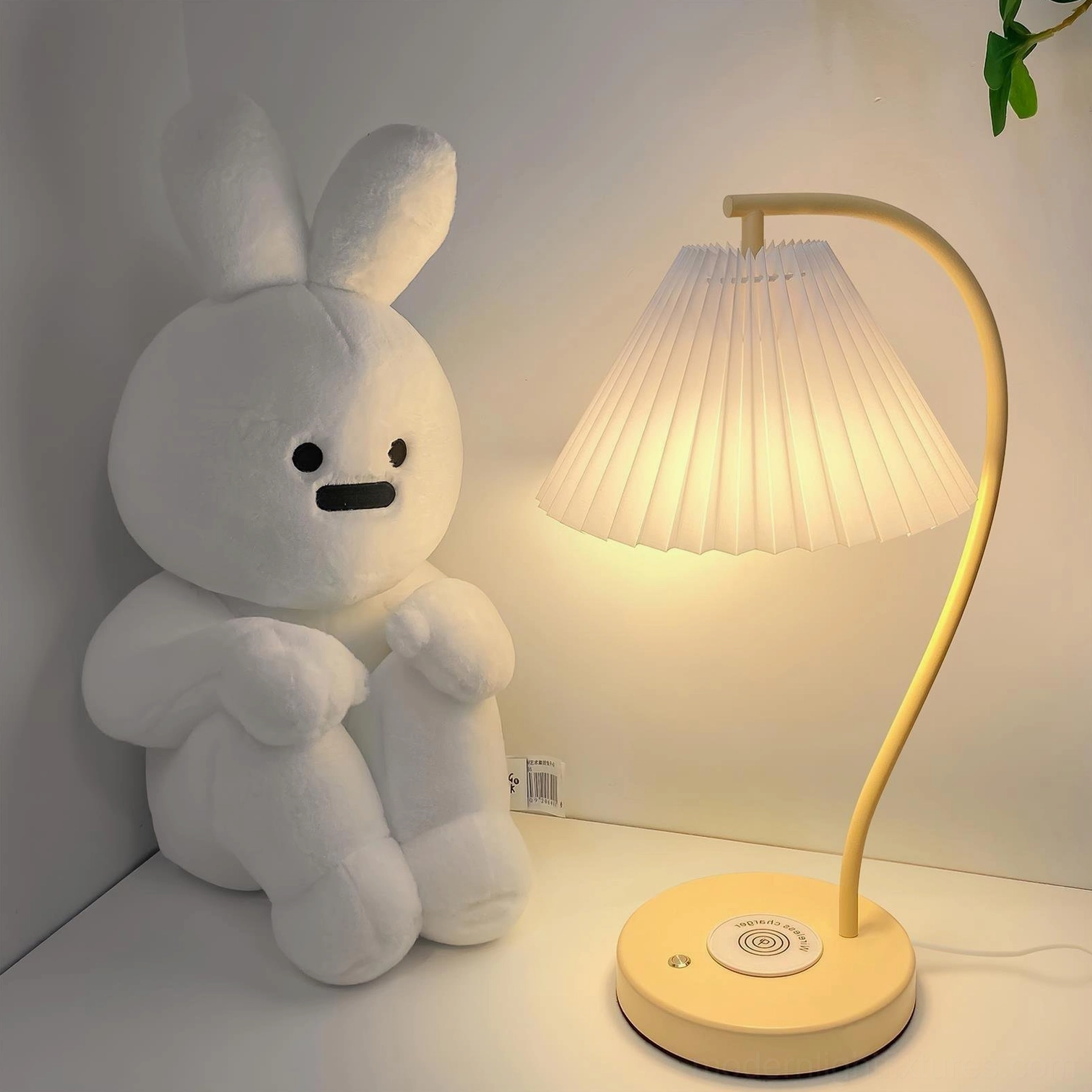 Contemporary pleated table lamp on bedroom dresser with soft warm illumination